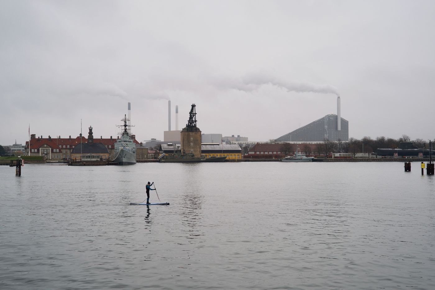 Paddle surfer with Copenhagen's CopenHill in the background